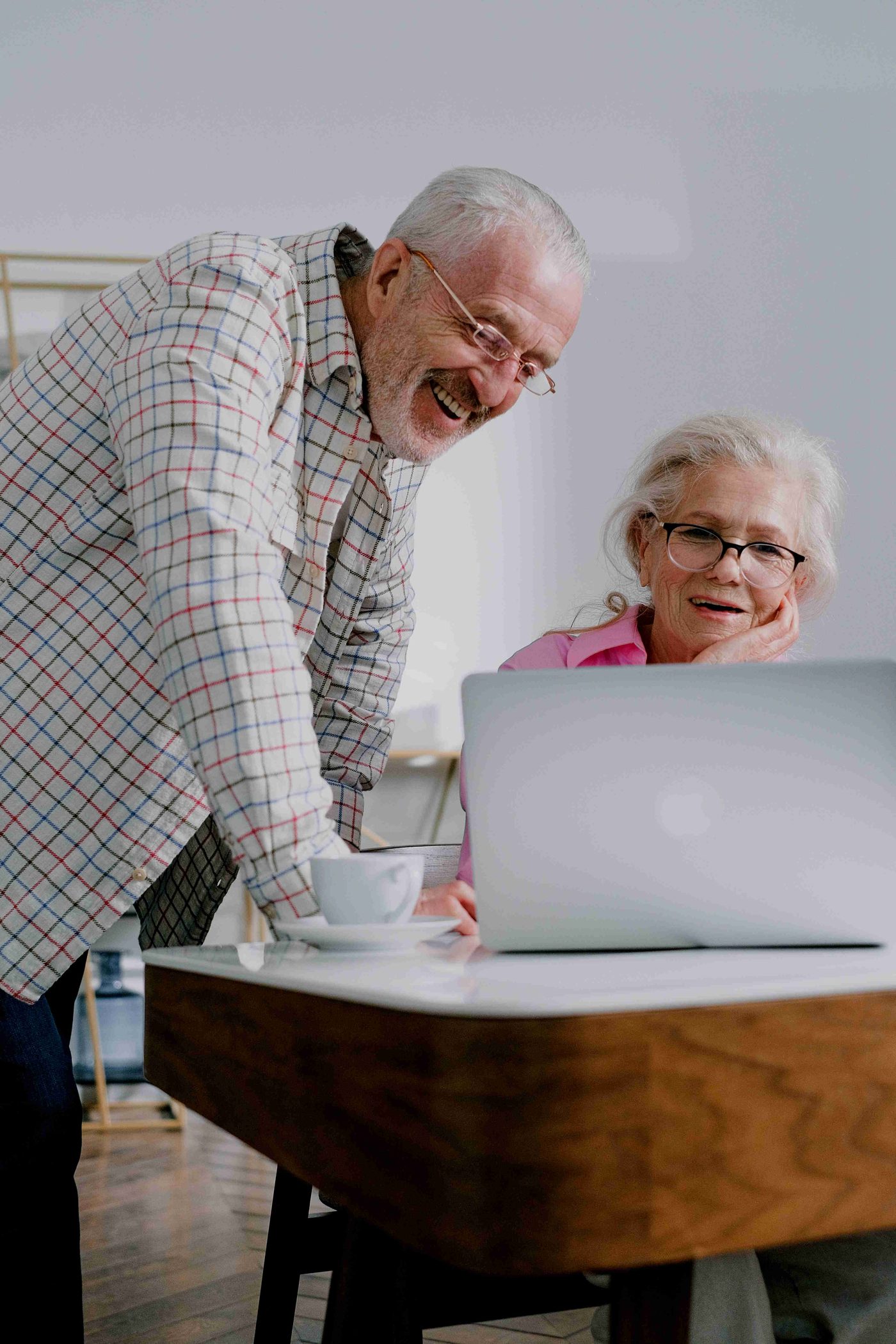 Un couple d'aînés souriant devant un ordinateur portable